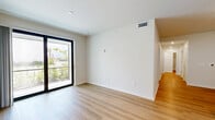 Located at 1905 Champs Drive in Naples, FL, this thoughtfully designed 4-bedroom, 3-bathroom unit offers a clean, modern aesthetic across a single floor. The open-concept kitchen and living area serves as the heart of the home, featuring crisp white shaker cabinetry, a subway tile backsplash, a large center island with quartz countertops, and a full suite of stainless steel appliances. Light wood-tone flooring flows seamlessly throughout the entire unit, creating a warm and cohesive atmosphere. The living area is bright and open, with access to a sliding glass door that welcomes natural light. Each of the four bedrooms is well-proportioned and finished with the same light wood flooring; several rooms include ceiling fans and windows with outdoor views of surrounding greenery. The primary bedroom is generously sized and features a dedicated walk-in closet outfitted with multi-tiered wire shelving for ample storage. The three bathrooms are consistently finished with white subway tile tub-shower combinations, white vanities with quartz countertops, and brushed nickel hardware. Recessed lighting throughout the unit adds a polished, contemporary feel, while the neutral color palette and clean lines create a bright, move-in ready environment.