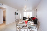 This single-floor residence offers a functional and comfortable layout across several well-defined living spaces. The living room serves as the heart of the home, featuring plush carpeting, a ceiling fan, and generous natural light from multiple windows fitted with blinds. The space comfortably accommodates a full seating arrangement and an adjacent dining area, making it ideal for both relaxing and entertaining.

The kitchen is efficiently designed with ample white cabinetry, taupe countertops, and durable tile flooring. It comes fully equipped with a full suite of white appliances, including a refrigerator, electric range, over-the-range microwave, and dishwasher, along with a double-basin sink.

The primary bedroom features soft carpeting, dual windows for natural light, a ceiling fan, and generous space for a full bedroom set. A second bedroom mirrors this comfortable style with its own window and ceiling fan. Both rooms offer a calm, restful atmosphere.

The full bathroom includes a single-sink vanity with white cabinetry, a toilet, and a shower/tub combination enclosed by sliding glass doors, all set on tile flooring. A dedicated laundry room houses a full-sized washer and dryer with additional overhead shelving and tile flooring, adding everyday convenience to the home.