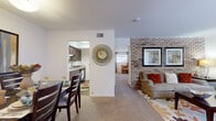 This thoughtfully designed single-floor residence offers a comfortable and functional layout across its well-utilized living spaces. The combined living and dining area serves as the heart of the home, highlighted by a striking exposed brick accent wall that adds texture and character to the space. The living room benefits from large windows dressed with sheer curtains, allowing generous natural light to fill the carpeted space. A dedicated dining area provides ample room for a full-size table, making it well-suited for both everyday meals and entertaining.

The kitchen features dark wood cabinetry, granite-style countertops, a stainless steel sink, built-in dishwasher, and a microwave, with wood-look flooring that adds warmth and durability. A pantry provides additional storage to keep the space organized.

The spacious primary bedroom offers plush carpeting, a large window with curtain panels, and enough room to comfortably accommodate a full furniture suite. Two closets throughout the home ensure ample storage.

The bathroom is finished with a granite-style vanity countertop, white cabinetry, wood-look flooring, a full tub-shower combination with white tile surround, and tasteful wall accents. The overall ambiance is warm, inviting, and move-in ready.