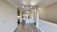 Located at 12025 Dessau Rd in Austin, TX, this one-bedroom, one-bathroom unit offers a well-designed layout across a single floor. The open-concept living and kitchen area is a standout feature, showcasing light wood-style flooring, crown molding, and track lighting overhead. The kitchen is equipped with white cabinetry, granite-style countertops, stainless steel appliances, and a peninsula with a sink — ideal for both cooking and casual dining. Built-in shelving adds functional storage near the dining area.

The living room benefits from large windows that invite abundant natural light and provide views of the surrounding neighborhood. A ceiling fan and clean, neutral walls create a calm and comfortable atmosphere throughout. A private exterior door with a transom window offers convenient access and additional light.

The bedroom is generously sized, featuring plush carpet, a ceiling fan, and a window with blinds for natural light and privacy. A dedicated closet provides practical storage, while a hallway connects the bedroom to the full bathroom. The staircase, finished with carpet treads and a clean white railing, adds a distinctive vertical element to the unit's layout. Overall, the space presents a functional and well-finished interior suited for comfortable everyday living in Austin.