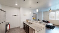 Located at 3601 Midland Ave in Memphis, TN, this thoughtfully designed 2-bedroom, 2-bathroom unit offers a functional and modern single-floor layout. The open-concept living area combines the kitchen, dining, and living spaces into one cohesive zone, finished with wood-style luxury vinyl plank flooring and neutral-toned walls that create a bright, clean aesthetic throughout.

The kitchen is a standout feature, equipped with stainless steel appliances including a refrigerator and range, dark espresso cabinetry, granite-style countertops, a double-basin sink, and a peninsula with bar seating illuminated by pendant lighting — ideal for both meal prep and casual dining.

The living room offers a comfortable, open feel with a ceiling fan, natural light from a large window with exterior views, and ample space for seating arrangements. Both bedrooms are well-proportioned, with the spacious primary bedroom offering generous room for furnishings, and the secondary bedroom featuring a bright window suited for use as a study or guest room.

Each bathroom is finished consistently with granite-style countertops, dark cabinetry, and tub/shower combinations with chrome fixtures. The unit also includes a dedicated laundry area and multiple closets for storage. The overall design is modern, clean, and move-in ready.