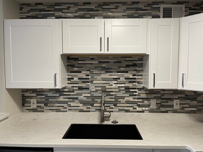 Modern tile backsplash covers two walls of the kitchen - 18333 Roehampton Dr