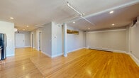 Located at 2920 Fifth Ave in Troy, NY, this one-bedroom, one-bathroom unit offers a well-designed single-floor layout with generous living space distributed across multiple rooms. Warm hardwood flooring flows consistently throughout, creating a cohesive and inviting atmosphere.

The expansive living area is divided into two connected zones, offering flexibility for both lounging and entertaining. Recessed lighting, track lighting, and baseboard heating are featured throughout, while exposed utility conduits lend a subtle industrial character to the space.

The combined kitchen and dining area is well-appointed with warm wood cabinetry, granite countertops, a stainless steel dishwasher, range, and refrigerator. Dark tile flooring in the kitchen contrasts neatly with the hardwood in the adjacent dining space. A row of windows brings in natural light and provides street-facing views.

The bedroom is generously sized and includes a dedicated closet with built-in rods for ample storage. Neutral gray walls and hardwood floors keep the room bright and versatile. The full bathroom features white tile flooring, a soaking tub with shower, and a dark wood vanity, offering a clean and functional design.

Two hallways connect the rooms efficiently, and an additional closet provides supplementary storage throughout this well-organized residence.