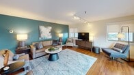 Located at 4001 Ninth Street North in Arlington, Virginia, this single-floor residence offers a thoughtfully designed layout with a cohesive blend of modern finishes and comfortable living spaces. Warm hardwood flooring flows throughout the main living areas, creating a unified aesthetic from room to room.

The galley-style kitchen is efficiently organized, featuring white shaker cabinetry, light quartz countertops, a subway tile backsplash, and stainless steel appliances including a range, microwave, dishwasher, and refrigerator. The kitchen opens toward the dining and living areas, enhancing the sense of connectivity throughout the space.

The dining area benefits from multiple windows with roller shades that admit generous natural light, while track lighting overhead provides adjustable illumination. The living room features a bold teal accent wall that serves as a visual focal point, complemented by track lighting and a window offering outdoor views.

The bedroom is a calm, neutral retreat finished with plush carpeting, a warm accent wall, and a window with exterior views. The bathroom presents white cabinetry, a quartz vanity top, and a well-lit mirror framed by modern sconce lighting. Overall, the residence delivers a clean, contemporary atmosphere suited to comfortable urban living.
