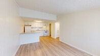 This thoughtfully designed 1-bedroom, 1-bathroom unit offers a functional and cohesive layout spread across a single floor. Light-toned hardwood-style flooring runs consistently throughout, giving the space a clean, unified aesthetic.

The open-concept kitchen and living area serves as the heart of the unit. The kitchen is equipped with white cabinetry, light marble-style countertops, a subway tile backsplash, white appliances including a refrigerator, dishwasher, and electric range, and a breakfast bar peninsula that provides both prep space and a natural division from the living area. A flush-mounted ceiling light fixture illuminates the kitchen. The adjoining living room receives natural light through a large window and features a textured ceiling.

The bedroom is a comfortable, well-proportioned room with a ceiling fan with light kit, a double-door closet, and a window that allows natural light to filter in. The neutral warm-beige walls and light flooring create a calm, restful atmosphere.

The bathroom includes a full-size soaking tub and shower combination, a vanity with white cabinetry, and clean white fixtures throughout. A dedicated laundry area provides washer and dryer hookups along with overhead cabinetry for additional storage, and houses the unit's water heater. A hallway connects all rooms, completing the efficient and practical floor plan.