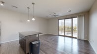 Located at 150 N McLean Blvd in Wichita, Kansas, this one-bedroom, one-bathroom unit offers a thoughtfully designed single-floor layout with a clean, modern aesthetic. The open-concept living and kitchen area is anchored by rich hardwood-style flooring and filled with natural light from large sliding glass doors that open to a private balcony overlooking the city skyline. A ceiling fan adds comfort to the living space, while stylish pendant lights illuminate the kitchen island below.

The kitchen is well-appointed with stainless steel appliances, including a refrigerator, range, and microwave, complemented by white cabinetry, a subway tile backsplash, and a dark-topped island that doubles as a breakfast bar. A long, light-filled hallway with recessed lighting connects the main living area to the private quarters.

The bedroom features soft wall-to-wall carpeting, a ceiling fan, and horizontal windows that allow natural light while maintaining privacy. A dedicated closet provides convenient storage. The bathroom is clean and functional, finished with a full soaking tub and shower combination with bright white shiplap-style surround. Neutral tones and consistent finishes throughout give the entire unit a cohesive, contemporary feel.