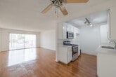 Located at 3711 W 230th St in Torrance, California, this single-floor residence offers a clean, functional layout designed for comfortable everyday living. The open living area is finished with warm hardwood-style flooring that reflects natural light streaming in through a full-width sliding glass door, which leads directly to a private balcony with views of the surrounding neighborhood. A ceiling fan adds comfort to the adjoining space, while textured ceilings throughout lend a classic character to the interior.

The galley-style kitchen is efficiently designed with white cabinetry lining both sides, light countertops, a stainless steel sink, and stainless appliances including a range and built-in microwave. Track lighting illuminates the workspace, making it both practical and bright.

The bedroom features plush carpeting, a window dressed with vertical blinds that filters soft natural light, and mirrored sliding closet doors that enhance the sense of space. The bathroom is finished with a white vanity countertop, framed mirrors, and brushed nickel fixtures, maintaining a clean and neutral aesthetic throughout.

With its bright, neutral palette and well-considered layout, this Torrance residence offers a welcoming and move-in ready environment in a well-established Southern California community.