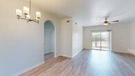 Located in Houston, TX, this well-appointed 2-bedroom, 2-bathroom residence offers a practical and comfortable single-floor layout. Light wood-style flooring flows consistently throughout the unit, creating a cohesive and bright aesthetic. The open-concept living area connects seamlessly to the dining space and kitchen, where warm-toned wood cabinetry, a tile backsplash, a peninsula breakfast bar with a neutral countertop, and white appliances — including a refrigerator, range, and over-the-range microwave — come together. An elegant arched passageway and a pendant chandelier above the dining area add architectural character. Ceiling fans are present in the living room and both bedrooms, promoting year-round comfort. Each bedroom is generously sized with natural light from large windows; the primary bedroom features a walk-in closet with built-in shelving. Both bathrooms are finished with wood-toned vanities, neutral countertops, large mirrors, and combination tub/shower units with tile surrounds. Additional highlights include a dedicated laundry area, six closets throughout for exceptional storage, and a private balcony. The overall ambiance is clean, neutral, and move-in ready.
