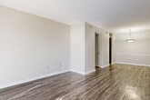 This single-story, two-bedroom, one-bathroom residence in Bessemer, Alabama, offers a clean and functional layout finished with consistent wood-look flooring throughout. The living area is well-proportioned and filled with natural light, courtesy of a sliding glass door dressed with vertical blinds that allow sunlight to reflect across the floors. The open flow from the living space leads into a dedicated dining area, distinguished by a pendant light fixture overhead and a direct sightline into the kitchen, which features dark cabinetry and black appliances. Neutral beige walls and white trim create a cohesive, understated palette across the entire unit.

Both bedrooms are comfortably sized, each receiving natural light through windows fitted with horizontal blinds. One bedroom includes access to a walk-in closet, while the other provides additional storage via a separate closet. The shared bathroom features a dark blue vanity with a granite-style countertop, a large mirror, wall-mounted lighting, and a full-size white tub-shower combination with tiled surround. Textured ceilings appear in select rooms, adding subtle architectural detail. The overall ambiance is bright, neutral, and move-in ready.
