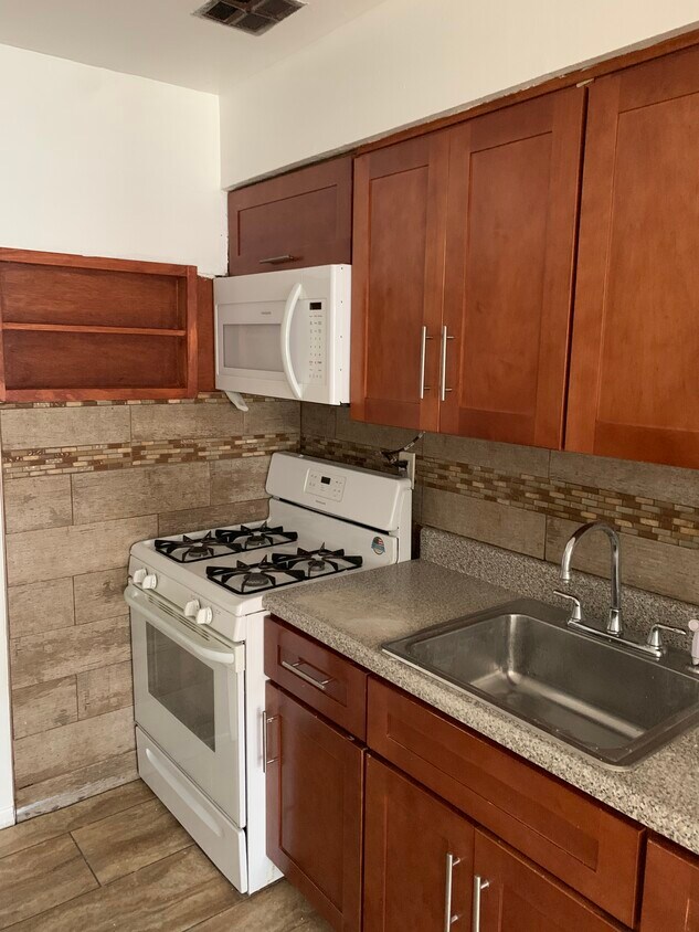 Shaker style cabinets with Glass porcelain mosaic tiles and custom built spice rack - 1156 E 223rd St