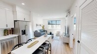 Located at 223 E High St in Moorpark, CA, this thoughtfully designed 2-bedroom, 1-bathroom single-story home offers a clean, modern aesthetic with an efficient, well-organized layout. Light hardwood flooring and crisp white walls flow throughout, creating a bright and cohesive ambiance.

The open-concept living and kitchen area forms the heart of the home. The kitchen features floor-to-ceiling white shaker cabinetry with matte black hardware, white quartz countertops, a subway tile backsplash, and a full suite of stainless steel appliances. A white kitchen island with bar seating provides additional workspace and casual dining. The adjacent living room is bathed in natural light from large windows with roller shades, and is equipped with a wall-mounted mini-split HVAC unit.

Both bedrooms are well-proportioned and bright, each featuring windows with outdoor views, recessed lighting, and individual mini-split climate control units. Two dedicated closets provide ample storage. The full bathroom offers a glass-enclosed tub-shower combination with white subway tile surround and matte black fixtures, complemented by a white vanity and hardwood-style flooring. A dedicated laundry area and connecting hallway complete the functional floor plan of this contemporary Moorpark residence.