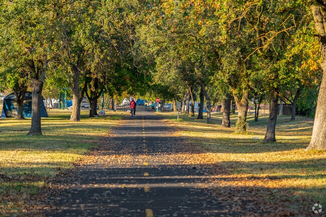 Locals ride bikes and walk dogs on beautiful pathway in Del Paso Heights.