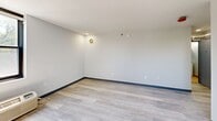 Located at 1930 Marion St in Columbia, SC, this two-bedroom, one-bathroom unit offers a clean, modern design across a single floor. Light gray walls and wood-style luxury vinyl plank flooring are consistent throughout, creating a cohesive and contemporary aesthetic.

The kitchen is well-appointed with warm wood-tone cabinetry extending to the ceiling, white countertops, a stainless steel sink, an electric range, a built-in microwave, and a dishwasher — providing full functionality in a compact, efficient layout.

The spacious primary bedroom is the largest room in the unit, offering generous square footage, neutral walls, and ample natural light from a window with views of the surrounding area. A baseboard heating unit lines the wall, ensuring year-round comfort. The second bedroom is similarly finished and includes a built-in closet with double hanging rods, maximizing storage.

The bathroom features warm beige tile flooring, a white vanity with mirror medicine cabinet, and clean white fixtures, maintaining a bright and functional design.

Throughout the unit, dark baseboards provide a modern contrast to the light walls and flooring. Recessed lighting and wall-mounted ventilation fixtures are integrated into the ceilings. The open floor plan, visible in the dollhouse view, reflects an efficient use of space suited for everyday living.