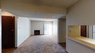 This single-floor residence offers a practical and comfortable layout designed for easy living. The spacious living room serves as the heart of the home, featuring soft wall-to-wall carpeting, a classic fireplace, and a sliding glass door fitted with vertical blinds that floods the space with natural light and provides access to the outdoors. A textured ceiling adds character throughout the living areas.

The kitchen is efficiently designed with warm wood cabinetry, white appliances including a coil-top range and dishwasher, light countertops, and easy-to-maintain tile flooring. A pass-through counter connects the kitchen to an adjacent dining or flex area, which is brightened by a ceiling fan with a light fixture overhead.

The bedrooms are generously sized, carpeted for comfort, and receive ample natural light through windows with blinds. The primary bedroom includes direct access to a private bathroom as well as a dedicated closet, providing convenient storage. An additional closet is also accessible from this room.

The full bathroom is clean and functional, featuring a tub-shower combination, a toilet, and a wood-trimmed vanity with a light countertop and a large mirror. The tile flooring adds a neat, polished finish to the space. Throughout the home, warm neutral tones and wood accents create a cohesive and welcoming ambiance.