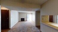 This single-floor residence offers a practical and comfortable layout designed for easy living. The spacious living room serves as the heart of the home, featuring soft wall-to-wall carpeting, a classic fireplace, and a sliding glass door fitted with vertical blinds that floods the space with natural light and provides access to the outdoors. A textured ceiling adds character throughout the living areas.

The kitchen is efficiently designed with warm wood cabinetry, white appliances including a coil-top range and dishwasher, light countertops, and easy-to-maintain tile flooring. A pass-through counter connects the kitchen to an adjacent dining or flex area, which is brightened by a ceiling fan with a light fixture overhead.

The bedrooms are generously sized, carpeted for comfort, and receive ample natural light through windows with blinds. The primary bedroom includes direct access to a private bathroom as well as a dedicated closet, providing convenient storage. An additional closet is also accessible from this room.

The full bathroom is clean and functional, featuring a tub-shower combination, a toilet, and a wood-trimmed vanity with a light countertop and a large mirror. The tile flooring adds a neat, polished finish to the space. Throughout the home, warm neutral tones and wood accents create a cohesive and welcoming ambiance.