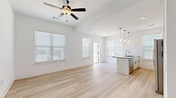Located at 760 NW Shoal Creek Parkway in Kansas City, MO, this well-appointed 1-bedroom, 1-bathroom unit offers a clean, modern aesthetic with thoughtfully designed spaces. The open-concept living and kitchen area is bathed in natural light from multiple windows dressed with blinds, and features light-toned hardwood-style flooring throughout. A ceiling fan anchors the living space, while the kitchen impresses with white shaker cabinetry, a white subway tile backsplash, stainless steel appliances including a refrigerator with ice maker, electric range, and built-in microwave, and a peninsula island with a dark countertop and pendant lighting above — ideal for both cooking and casual dining. A private balcony accessed from the living area offers open views of the surrounding Kansas City neighborhood and tree-lined streetscape. The bedroom is a comfortable, carpeted retreat with a ceiling fan and a window allowing natural light to filter in. A walk-in closet with wire shelving provides practical storage. The full bathroom features white shaker-style cabinetry with matte black hardware, a single vanity with a neutral countertop, and a tub/shower combination — all finished in a crisp, bright palette that enhances the sense of space.