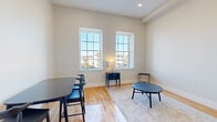 This well-designed two-bedroom, one-bathroom unit on Mason Street in Fall River, Massachusetts, makes efficient use of its single-floor layout. The living room serves as the heart of the space, distinguished by tall ceilings, warm hardwood flooring, and a pair of large double-hung windows that frame neighborhood views and flood the room with abundant natural light. The neutral, light-toned walls enhance the open, airy feel throughout.

The galley-style kitchen is thoughtfully appointed with white shaker cabinetry, granite countertops, a stainless steel sink, and stainless steel appliances including an electric range and built-in microwave. Hardwood floors continue seamlessly from the living area into the kitchen, reinforcing a cohesive aesthetic. A hallway connects the main living spaces to the private quarters.

The primary bedroom is a cozy, well-proportioned room with hardwood floors, neutral walls, and a wall-mounted HVAC unit for climate control. The second bedroom mirrors the clean, minimal style of the rest of the unit. The bathroom features a tub-shower combination with sleek sliding glass doors and a clean, all-white finish. Overall, the unit offers a modern, functional living environment with consistent finishes throughout.