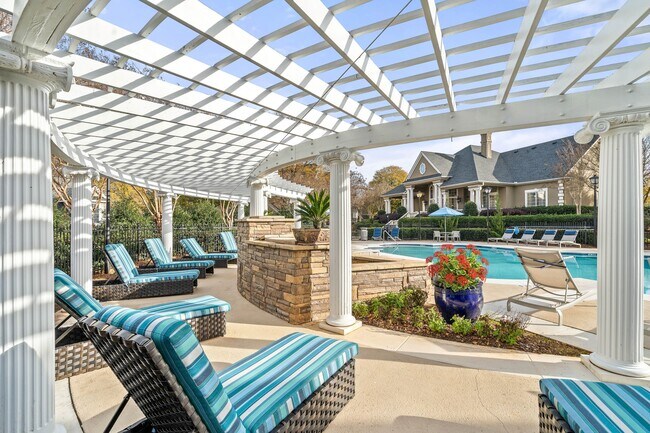 Amplia terraza junto a la piscina con sillas de salón en Hawthorne at the Carlyle en Greenville, SC - Hawthorne at the Carlyle