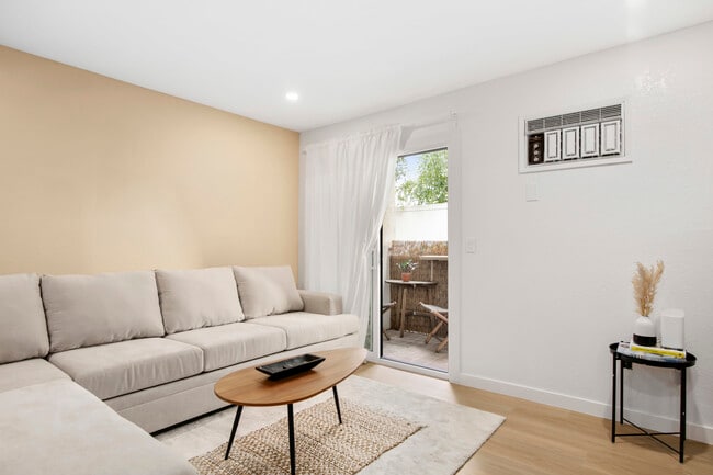 Spacious lounge with comfy sofa and patio access – ideal for indoor-outdoor living. - 1013 S Sunshine Ave