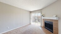 This single-story, 2-bedroom, 1-bathroom residence in Killeen, Texas offers a well-organized layout designed for comfortable everyday living. The living room serves as the centerpiece of the home, featuring plush carpeting, neutral-toned walls, and a textured ceiling. A wood-mantled fireplace with a warm tile surround anchors the room, while a large sliding glass door floods the space with natural light and provides access to the outdoors. The bedrooms are carpeted and finished in soft neutral tones. The primary bedroom is a comfortable size, equipped with a ceiling fan with light fixture and a window that allows natural light to filter in. Closet space is well-represented, including a walk-in closet with mirrored sliding doors and built-in shelving. The full bathroom features warm wood-toned cabinetry, a vanity with a well-lit mirror, tile flooring, and overhead lighting. A dedicated laundry area accommodates a full-size washer unit with overhead shelving for added storage. The hallway connects all rooms efficiently, contributing to the home's practical and functional flow throughout. The consistent use of neutral colors and carpet creates a cohesive, move-in ready environment suited for a range of lifestyles.