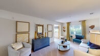 Located at 5003 Winster Dr in Winston-Salem, NC, this single-floor, 3-bedroom, 2-bathroom home offers a well-designed layout across a comfortable footprint. The living room serves as the heart of the home, featuring plush carpet, large windows that invite natural light and outdoor views, and a welcoming atmosphere accentuated by a bold blue and gold color palette. A dedicated dining area adjoins the kitchen, highlighted by wood-look flooring and tasteful wall art, creating a seamless transition between spaces. The kitchen is equipped with standard appliances and offers functional workspace. The primary bedroom is a serene retreat, complete with a ceiling fan, a generous window with lush outdoor views, and soft carpeting. It connects directly to one of the two full bathrooms, which features wood-look flooring, a granite-topped vanity with warm wood cabinetry, and a shower-tub combination. The second full bathroom mirrors this design with similar finishes. Two additional bedrooms provide flexible space for guests or home office use. Throughout the home, bright white walls, consistent flooring choices, and a cohesive decorative style create a unified and inviting ambiance. Two closets provide practical storage solutions to complement the thoughtful layout.