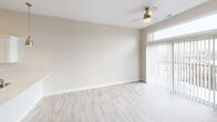 Located at 900 3rd St SE in Cedar Rapids, Iowa, this well-appointed one-bedroom, one-bathroom unit offers a clean, modern aesthetic with thoughtfully selected finishes throughout. The open-concept kitchen and living area serves as the heart of the home, featuring light hardwood-style flooring, crisp white shaker cabinetry, white quartz countertops, and a full suite of stainless steel appliances including a refrigerator, electric range, and over-the-range microwave. The living area is bathed in natural light from a large sliding glass door that opens to a balcony, offering views of the surrounding Cedar Rapids cityscape. A ceiling fan overhead adds both function and comfort to the space. The bedroom is a comfortable retreat with plush carpeting, a ceiling fan, and a large window framing urban views. Neutral warm-beige tones on the walls create a calm, cohesive atmosphere throughout. The full bathroom is finished with light wood-look flooring, a soaking tub with brushed nickel fixtures, and a clean white vanity with storage. A dedicated laundry area includes a stacked Samsung washer and dryer alongside ample wire shelving for storage, adding significant everyday convenience to this efficiently designed urban residence.