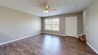 Located in Clinton, Iowa, this two-story home offers a well-organized layout across two levels. The main floor features an open-concept kitchen and living area finished with rich hardwood-style flooring and a ceiling fan with light. The kitchen is outfitted with white shaker-style cabinetry, granite countertops, a peninsula with seating, tile backsplash, and a full suite of stainless steel appliances including a refrigerator with ice maker, electric range, and microwave. A convenient half bathroom is also found on the main level. The attached garage features a concrete floor, paneled ceiling with built-in lighting, and an electrical panel, with direct interior access to the home. Upstairs, two bedrooms are carpeted and filled with natural light through large windows, each equipped with a ceiling fan. The spacious primary bedroom includes a walk-in closet with built-in shelving and hanging rods. The upper level hosts two full bathrooms — one featuring a tub/shower combination, white vanity cabinetry, and tile flooring, while another offers a clean, minimal design with hardwood-style flooring. A utility room and hallway round out the upper floor, providing practical storage and circulation throughout this thoughtfully designed home.