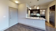 This one-bedroom, one-bathroom residence on Broadway offers a well-designed single-floor layout with contemporary finishes throughout. Wood-style flooring runs through the main living areas, complementing the clean, neutral color palette and recessed lighting. The open-concept living and dining area is generously proportioned, featuring a ceiling fan, track lighting, and large windows that allow natural light to fill the space.

The kitchen is outfitted with dark espresso cabinetry, granite countertops, a subway tile backsplash, and a full suite of stainless steel appliances, including a refrigerator with ice maker, gas range, microwave, and a wine/beverage cooler. Pendant lighting illuminates the breakfast bar peninsula, which provides additional prep and seating space.

The bathroom features a dual-sink vanity with granite countertops, dark cabinetry, a large mirror, and wood-style flooring. It leads directly into a spacious walk-in closet outfitted with wire shelving and carpeted flooring, offering substantial storage. A dedicated in-unit laundry area with side-by-side washer and dryer connections adds practical convenience to the overall layout.