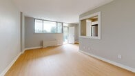 Located at 103 West Lodge Avenue in Toronto's vibrant Parkdale neighbourhood, this one-bedroom, one-bathroom unit offers a well-planned layout across a single floor. Light hardwood flooring runs throughout, contributing to a clean, cohesive aesthetic.

The kitchen is efficiently designed with white cabinetry, light countertops, and stainless steel appliances including a range and refrigerator. It opens toward the living area through a pass-through window, maintaining a sense of connection between the spaces.

The living room is bright and open, featuring large floor-to-ceiling windows that invite generous natural light and offer leafy outdoor views. A wall-mounted heating unit provides comfort year-round, and a door leads directly to an outdoor space, enhancing the unit's accessibility to fresh air.

The bedroom is a comfortable, quiet space with a built-in sliding-door closet for ample storage. Light-toned walls and the same hardwood flooring create a restful atmosphere, complemented by a window that brings in additional natural light.

The bathroom is finished with neutral tile flooring and includes a full soaker tub with shower, a vanity, and clean white surrounds throughout.

Overall, the unit presents a functional and well-lit living environment with a neutral palette, making it an adaptable space suited to a variety of lifestyles.