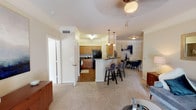Located at 7800 N Sam Houston Pkwy E in Humble, TX, this single-story unit offers a well-designed, open-concept floor plan that seamlessly connects the main living areas. The kitchen is outfitted with warm honey-toned cabinetry, dark granite countertops, a subway tile backsplash, and black appliances, including a full-size refrigerator and range. A breakfast bar with pendant lighting bridges the kitchen to the dining area, which features crown molding and space for a full dining set. The living room is bright and inviting, with carpet flooring, crown molding, a ceiling fan, and a glass door that allows natural light to flow in while providing outdoor access. Two bedrooms offer comfortable retreats, each with carpet flooring, ceiling fans, and ample closet space. The primary bedroom includes natural light from a window with stylish curtains. Both bathrooms are functional and well-appointed, featuring tub-shower combinations, wood-look flooring, and vanity storage. Throughout the unit, neutral wall tones and consistent trim details create a cohesive and welcoming ambiance suited for everyday living.