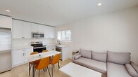 Located at 2618 College Ave in Berkeley, CA, this accessory dwelling unit (ADU) offers a thoughtfully designed single-floor layout with five bedrooms and two full bathrooms. The interior features a clean, modern aesthetic throughout, with light wood flooring and crisp white walls that create a bright, cohesive atmosphere.

The kitchen is a standout feature, showcasing white shaker cabinetry, marble-look quartz countertops, stainless steel appliances including a range, microwave, and dishwasher, and a central island with seating — all illuminated by recessed lighting and a window that invites natural light.

Each bedroom is efficiently laid out with large windows fitted with slatted blinds, offering views of surrounding greenery. Several rooms include individual mini-split HVAC units for personalized climate control, and select bedrooms feature wardrobe storage. The rooms share a calm, neutral palette that maximizes the sense of space.

Both bathrooms are finished consistently with white subway tile tub-surround surrounds, marble-look vanity countertops, wood-look flooring, and matte black fixtures and hardware, lending a polished, contemporary feel. Windows in each bathroom provide natural ventilation. A connecting hallway ties all rooms together in a functional and accessible single-level floor plan.