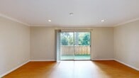 Located at 1735 Woodland Avenue in East Palo Alto, California, Studio 54 is a thoughtfully designed single-floor unit that makes efficient use of its compact footprint. The living room serves as the heart of the space, featuring warm hardwood flooring, crown molding, and recessed lighting that create a clean, polished ambiance. Large sliding glass doors open directly onto a private balcony, flooding the interior with natural light and offering pleasant views of the surrounding greenery and mature trees.

The kitchen is positioned adjacent to the living area and features white cabinetry, white appliances including a range, and tile flooring — providing a functional and bright workspace. A hallway connects the main living area to the more private portions of the unit, leading to two full bathrooms. Both bathrooms are finished with tile flooring, and one features a granite-topped vanity with white cabinetry and a separate shower stall with glass enclosure. The clean white finishes throughout the bathrooms contribute to a bright, airy feel.

Three closets provide ample storage throughout the unit. The overall design balances practicality with comfort, offering a well-organized layout suited for everyday living in the heart of the San Francisco Bay Area.