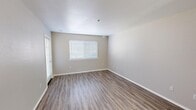 Located at 300 Burton Mesa Blvd in Lompoc, California, this single-floor, one-bedroom, one-bathroom unit offers a practical and comfortable layout with clean, neutral finishes throughout. The living area is finished with warm wood-look luxury vinyl plank flooring and neutral gray walls, creating a bright and inviting atmosphere enhanced by natural light from window blinds.

The kitchen features a U-shaped layout with crisp white cabinetry, tile countertops with a peninsula breakfast bar, a gas range, built-in microwave, and a double sink beneath a window — providing both functionality and natural light. The space transitions smoothly into the open living area, making it well-suited for everyday living.

The bedroom is a generously sized, carpeted retreat with a large window that fills the room with natural light. It includes a wide sliding-door closet with built-in shelving and hanging rods, offering ample storage. An additional closet in the hallway provides extra organization options.

The bathroom is thoughtfully designed with accessibility in mind, featuring grab bars around the tub/shower combination, wood-look flooring, built-in wall shelving, and a clean white vanity. The overall design of the unit is cohesive, functional, and move-in ready.