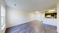 The Fox is a premium 1-bedroom, 1-bathroom unit thoughtfully designed to maximize both comfort and functionality across a single floor. The open-concept living area features smooth hardwood-style flooring in a cool gray-brown tone, clean white walls, and a textured ceiling, creating a bright and neutral canvas. Ample built-in closet storage with bifold doors lines the transition area between the living room and kitchen, providing excellent organizational capacity.

The kitchen is equipped with dark espresso cabinetry, a gas range, stainless steel refrigerator, and a granite-topped breakfast bar peninsula that separates the cooking area from the main living space — ideal for casual dining or entertaining.

The bedroom is generously sized with plush carpeting, a large window that invites natural light and outdoor views, and easy access to a closet and the full bathroom. The overall layout flows intuitively from the living area through the kitchen and into the private bedroom wing.

Throughout the unit, consistent finishes — including matching flooring, white trim, and modern light fixtures — lend a cohesive and polished feel. The Fox delivers a well-appointed, move-in-ready living experience with practical storage solutions and contemporary design details at every turn.