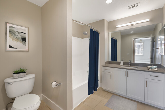 Renovated Package I bath with white cabinetry, grey quartz countertops, and hard surface flooring - Avalon Oak Creek