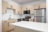 Located in Idaho Falls, ID, this thoughtfully designed one-bedroom, one-bathroom unit offers a clean, modern aesthetic across a single floor. The open-concept living and kitchen area serves as the heart of the home, featuring light wood-toned cabinetry, a large kitchen island with a white quartz-style countertop, and a full suite of stainless steel appliances including a refrigerator, range, microwave, and dishwasher. Recessed lighting illuminates the space, while light hardwood flooring flows throughout the main living areas, creating a warm and cohesive atmosphere. A pantry adds convenient storage to the kitchen. The spacious primary bedroom is finished with plush carpeting, a ceiling fan, and a large window that invites natural light. Three closets provide generous storage throughout the unit. The bathroom features a light wood vanity with black hardware accents, a white countertop, a large mirror, and a full bathtub and shower combination. In-unit laundry adds everyday convenience. A private balcony offers an outdoor retreat. The overall design is bright, clean, and contemporary, with a neutral palette that creates a welcoming and functional living environment.