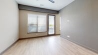 Located at 301 Nichols St in Fort Worth, TX, this contemporary single-floor studio offers a thoughtfully designed open-concept layout that efficiently combines the kitchen and living areas. The kitchen is a standout feature, showcasing dark espresso cabinetry, stainless steel appliances including a refrigerator, range, and microwave, complemented by a subway tile backsplash and a peninsula with a white quartz countertop and undermount sink — ideal for both meal prep and casual dining. Light wood-look flooring flows consistently throughout the space, contributing to a clean, modern aesthetic. The living area is bright and versatile, benefiting from recessed lighting and large windows fitted with blinds that allow for natural light control. A glass-paneled door leads to a private balcony offering open urban views of the Fort Worth skyline and surrounding neighborhood. The bathroom is well-appointed with a dark vanity, tile flooring, and a glass-enclosed walk-in shower with floor-to-ceiling tile surround. A dedicated closet and an in-unit stacked washer and dryer add practical convenience. The overall design is characterized by neutral tones, clean lines, and modern finishes throughout.