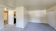 Located at 2416 W Garrison Ave in Baltimore, MD, this single-floor unit offers a practical and comfortable layout throughout. The living area is generously sized, featuring soft wall-to-wall carpeting, neutral-toned walls, and a ceiling fan with light fixture. Large windows allow natural light to pour in, offering views of the surrounding neighborhood streetscape. The space flows seamlessly into a dedicated kitchen area, which is equipped with warm honey-toned wood cabinetry, white countertops, a stainless steel sink, and black appliances including a range, dishwasher, and refrigerator. The kitchen features durable wood-look vinyl plank flooring, providing a clean contrast to the carpeted living spaces. The bedrooms continue the consistent aesthetic with plush carpeting, neutral walls, and ample closet storage. Windows in the bedrooms bring in natural light and outdoor views. The bathroom is finished with wood-toned cabinetry, a white sink and countertop, a medicine cabinet mirror with overhead lighting, white tile wainscoting, and wood-look flooring. Clean lines and a neutral palette throughout give the unit a bright, move-in ready feel.