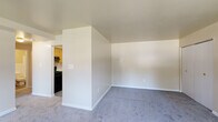 Located at 2416 W Garrison Ave in Baltimore, MD, this single-floor unit offers a practical and comfortable layout throughout. The living area is generously sized, featuring soft wall-to-wall carpeting, neutral-toned walls, and a ceiling fan with light fixture. Large windows allow natural light to pour in, offering views of the surrounding neighborhood streetscape. The space flows seamlessly into a dedicated kitchen area, which is equipped with warm honey-toned wood cabinetry, white countertops, a stainless steel sink, and black appliances including a range, dishwasher, and refrigerator. The kitchen features durable wood-look vinyl plank flooring, providing a clean contrast to the carpeted living spaces. The bedrooms continue the consistent aesthetic with plush carpeting, neutral walls, and ample closet storage. Windows in the bedrooms bring in natural light and outdoor views. The bathroom is finished with wood-toned cabinetry, a white sink and countertop, a medicine cabinet mirror with overhead lighting, white tile wainscoting, and wood-look flooring. Clean lines and a neutral palette throughout give the unit a bright, move-in ready feel.