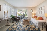 Located at 16350 S Harbor Blvd in Santa Ana, California, this single-story residence offers a thoughtfully designed layout with a warm, inviting ambiance throughout. The kitchen is well-equipped with white cabinetry, granite-style countertops, recessed lighting, wood-look flooring, and white appliances including a range, over-the-range microwave, and refrigerator — providing a clean and functional cooking space. Adjacent to the kitchen, a dedicated dining area features a ceiling fan, large vertical-blind windows that invite natural light, and views of the surrounding greenery. The living room is generously sized and bright, with large sliding glass doors opening to a private outdoor patio area framed by mature landscaping. Soft carpet and abundant natural light make this space particularly comfortable. The bedrooms are well-proportioned, carpeted, and filled with natural light through large windows with vertical blinds. One bedroom includes a walk-in closet, adding practical storage. The bathroom is neatly finished with wood-look flooring, a granite-style vanity countertop, white cabinetry, and a tub-shower combination. Overall, the residence presents a cohesive, comfortable living environment with a neutral palette and functional design throughout.