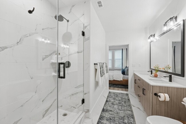 Baño con encimeras de cuarzo, lavabos dobles, ducha amplia y vestidor. - Linz Bayview