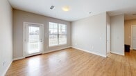 This contemporary 890 square foot apartment offers a well-designed living space with two bedrooms and two bathrooms. The open-concept layout seamlessly integrates the kitchen, living, and dining areas, creating a spacious feel. The kitchen is a standout feature, boasting white cabinetry, granite countertops, and stainless steel appliances, including a over-the-range microwave. A central island provides additional workspace and casual dining options.

The primary bedroom, measuring 150 square feet, offers ample space and includes a built-in closet. Both bedrooms feature neutral carpeting, while the main living areas and bathrooms are finished with durable wood-look flooring. Large windows throughout allow for plenty of natural light, and some rooms offer outdoor views.

The bathrooms are modern and functional, with one featuring a shower/tub combination and the other a walk-in shower. Both have granite countertops and ample storage space. The apartment's neutral color palette, primarily in shades of white and beige, provides a clean, fresh backdrop for personal decorating styles. Recessed lighting and pendant fixtures add to the contemporary ambiance of this efficiently designed living space.