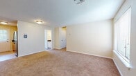 Located at 401 Talcottville Rd in Vernon Rockville, Connecticut, this single-floor unit offers a practical and comfortable layout designed for everyday living. The galley-style kitchen is well-equipped, featuring warm honey-toned cabinetry, dark granite countertops, stainless steel appliances including a gas range with microwave above, and a double sink. A window above the exterior door allows natural light to brighten the cooking space. The open living area is generously sized, finished with wall-to-wall carpeting and neutral-toned walls that create a clean, versatile backdrop. Multiple windows fitted with blinds allow ample natural light throughout. The bedrooms are spacious and carpeted, each with closet access and windows that bring in outdoor views. The bathroom is thoughtfully finished with tile flooring in an earthy stone pattern, a white vanity with dark granite countertop, an illuminated mirror, and a shower-tub combination. A second bathroom area features similar finishes with tile flooring, a white vanity, and a window for natural ventilation. The textured ceilings and consistent neutral color palette throughout lend the space a cohesive and move-in ready feel.