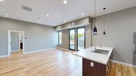 Located at 36 S Sixth St in Easton, PA, this well-appointed 2-bedroom, 2-bathroom unit offers a thoughtfully designed single-floor layout that balances modern aesthetics with everyday functionality. Light-toned hardwood floors run throughout the space, complementing the neutral gray walls and recessed lighting that brighten every room.

The open-concept kitchen and living area serves as the heart of the unit. The kitchen is outfitted with rich dark-wood cabinetry, a white quartz waterfall island with an undermount sink, stainless steel appliances including a gas range and French door refrigerator, and sleek pendant lighting that adds a contemporary touch.

Both bedrooms are generously proportioned, with the primary bedroom offering a comfortable footprint. Each bedroom features the same warm hardwood flooring and neutral tones, with access to natural light through modern black-framed windows that frame outdoor greenery.

The two bathrooms are distinctly styled yet equally refined. One features white marble-style tile surrounding a walk-in glass shower, dark slate flooring, and a stacked in-unit washer and dryer. The second bathroom showcases dark veined marble tile, a floating vanity, an LED-lit mirror, and a glass-enclosed shower, delivering a spa-like experience. Together, these spaces reflect a clean, modern design sensibility throughout.