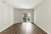 Located at 11405 Central Avenue in Chino, CA, this well-appointed 2-bedroom, 2-bathroom single-floor residence offers a thoughtfully designed layout with a clean, neutral aesthetic throughout. The open-concept living and dining area is anchored by rich wood-style flooring and warm beige tones, creating a bright and welcoming atmosphere. Sliding glass doors lead to a private patio, filling the space with natural light and offering pleasant outdoor views. A pendant light fixture accents the dining area near the entryway. The kitchen features white shaker cabinetry, granite-style countertops, stainless steel appliances including a gas range, microwave, and dishwasher, along with a stainless steel sink — a functional and stylish cooking space. Both bedrooms are carpeted for comfort, with large windows that bring in natural light and views of the surrounding greenery. Each bedroom includes closet space. The two bathrooms are finished with wood-style flooring, granite-style vanity countertops, white cabinetry, and large mirrors. One bathroom features a full tub and shower combination. Additional highlights include a laundry area, a hallway connecting the private spaces, and multiple closets for ample storage throughout.