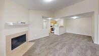 This 2-bedroom, 2-bathroom residence in Brownsburg, Indiana offers a well-organized single-floor layout with a warm, neutral color palette throughout. The open-concept living and kitchen area serves as the heart of the home, where plush carpeting flows through the spacious living room, anchored by a tiled fireplace. The kitchen features warm wood-toned cabinetry, white appliances including a range and microwave, and a convenient breakfast bar peninsula that opens to the living area — ideal for both cooking and casual dining.

Both bedrooms are carpeted and filled with natural light from large windows that offer views of the surrounding neighborhood. The primary bedroom is generously sized and includes access to a walk-in closet outfitted with full wire shelving systems for ample storage. A second closet provides additional organization options.

The two bathrooms are finished with light wood-look flooring and white vanities. One bathroom features a tub/shower combo with chrome fixtures. The laundry area includes an electrical panel, adding practical utility to the home.

A hallway connects the main living spaces, keeping the layout efficient and functional. The overall ambiance is clean, bright, and move-in ready, making this a comfortable residence in a quiet Brownsburg community.