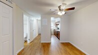 Located at 33 Meeting House Rd in Centerville, Ohio, this two-floor residence offers a practical and well-organized layout across both levels. The main living area is spacious and open, featuring warm hardwood-style flooring and a ceiling fan that adds both function and a classic touch. Large closet panels line one wall, providing generous built-in storage, while the open sightline connects seamlessly to the kitchen and entry hallway.

The kitchen is equipped with rich warm-toned wood cabinetry, light countertops, a double-basin stainless steel sink, and a black electric range with an overhead ventilation hood. A window above the kitchen area allows for natural light to filter in throughout the day.

A standout feature on the lower level is a bright room with French doors that open outward, inviting natural light and offering direct outdoor access. This room's hardwood-style flooring and paneled ceiling give it a distinct, versatile character.

The bedrooms are carpeted for comfort and feature neutral walls with natural light provided by blinds-fitted windows. One bedroom includes two windows, enhancing its brightness. The bathroom includes a full-size soaking tub and shower combination with clean white surrounds and brushed nickel fixtures. Throughout the space, clean white trim and neutral tones create a cohesive, move-in-ready atmosphere.