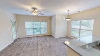 Located at 8310 Carter Creek Dr in Charlotte, NC, this single-floor residence offers a well-designed, functional layout with a warm and inviting ambiance throughout. The open-concept living and dining area is generously proportioned, finished with plush carpeting and bathed in natural light from multiple large windows with blinds. Ceiling fans provide comfort and airflow, while a stylish pendant light adds a decorative accent near the kitchen transition. The kitchen is thoughtfully appointed with white shaker-style cabinetry, a classic subway tile backsplash, a white quartz-style countertop with a breakfast bar overhang, and a full suite of black appliances including a range, microwave, and refrigerator. Hardwood flooring grounds the kitchen space, creating a clean contrast to the carpeted living areas. The bedrooms are comfortably sized with soft carpet, natural light from windows, and ample wall space for flexible furnishing. A dedicated in-unit laundry area houses a full-size washer and dryer with overhead shelving for added storage. The full bathroom features a single-sink vanity with white cabinetry, a tub-shower combination, and hardwood flooring, completing this practical and comfortable home.