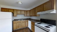 Located at 1789 Elaine Road in Columbus, Ohio, this two-story home offers a practical and well-organized layout across two floors. The kitchen is a standout functional space, showcasing warm oak cabinetry that extends to the upper walls, providing generous storage throughout. Dark laminate countertops run along an L-shaped configuration, offering ample prep space for cooking and entertaining. The kitchen is equipped with a white coil-burner range, a dishwasher, and a double basin sink, all seamlessly integrated into the cabinetry for a cohesive look. An overhead range hood is positioned above the stove, and a flush-mount ceiling light keeps the space well-lit. The flooring features durable dark vinyl tile, adding contrast to the lighter cabinetry tones. The neutral wall tones throughout create a clean, move-in-ready aesthetic. Spanning two floors, the home provides a versatile layout with room for living, dining, and sleeping areas distributed across its levels. The overall ambiance is practical and comfortable, making this Columbus property a solid residential option with thoughtfully arranged spaces designed for everyday living.