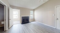 Located at 7529 Murray Hill Rd in Columbia, MD, this two-bedroom, one-bathroom single-floor home offers a thoughtfully arranged layout with a welcoming mix of comfort and functionality. The living room serves as the heart of the home, featuring a classic fireplace with a white surround and dark hearth, light wood-look flooring, and multiple windows that invite natural light and outdoor views, creating a bright and inviting atmosphere. A separate den provides flexible additional living space, finished with carpet and neutral warm-toned walls. The kitchen connects conveniently to the main living areas, supporting an efficient everyday flow. Both bedrooms are carpeted and well-proportioned, with the spacious primary bedroom offering generous square footage and ample closet access. The second bedroom benefits from dual windows that fill the room with natural light and includes its own closet. With four closets total throughout the home, storage is plentiful. The full bathroom features a single-sink vanity with wood cabinetry, a large mirror, and a tub-shower combination with clean white tile. A dedicated in-unit laundry area houses a full-size washer and includes overhead shelving for added convenience. The home's neutral color palette and practical design make it a comfortable and functional residence.